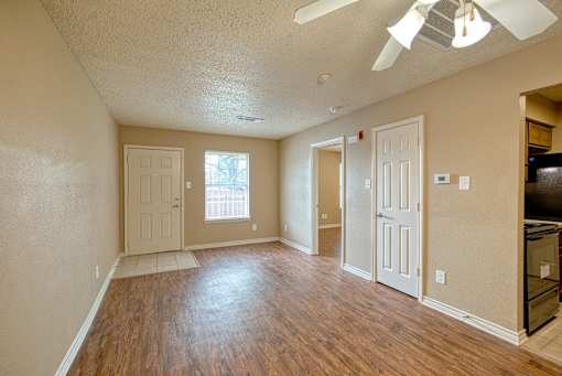 A room with wooden floors and a ceiling fan.