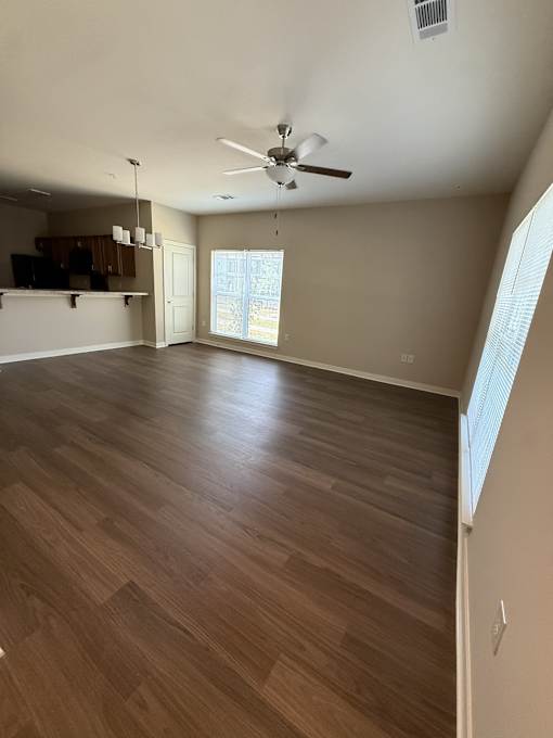 A room with wooden flooring and a ceiling fan.