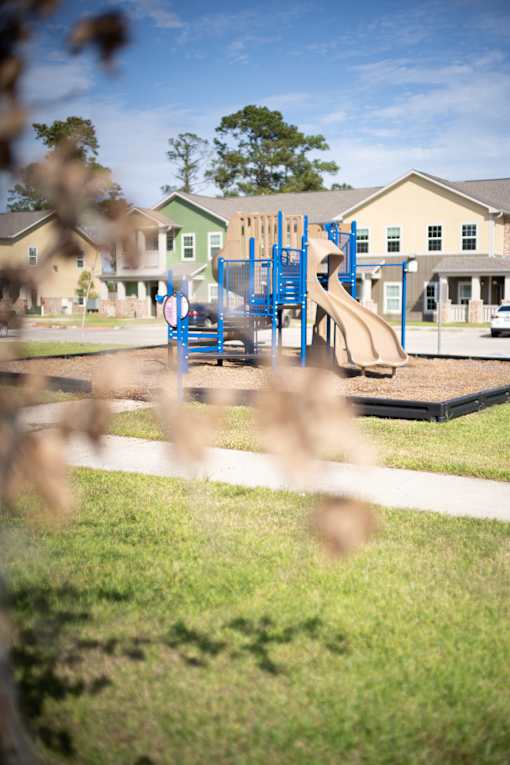 A playground with a blue slide and a red and white sign.