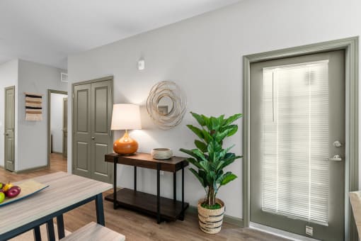a living room with two doors and a table with a plant