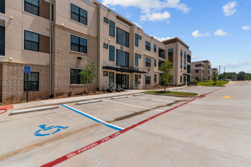 an empty parking lot in front of an apartment building