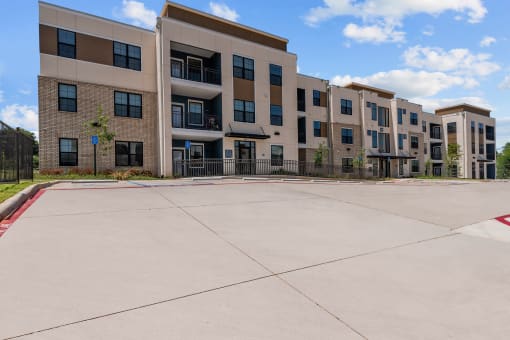 an empty parking lot in front of an apartment building