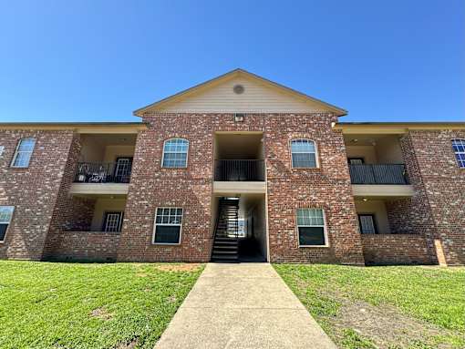 A brick building with a clear blue sky above it.