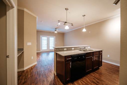 A kitchen with dark wood cabinets and a granite countertop.