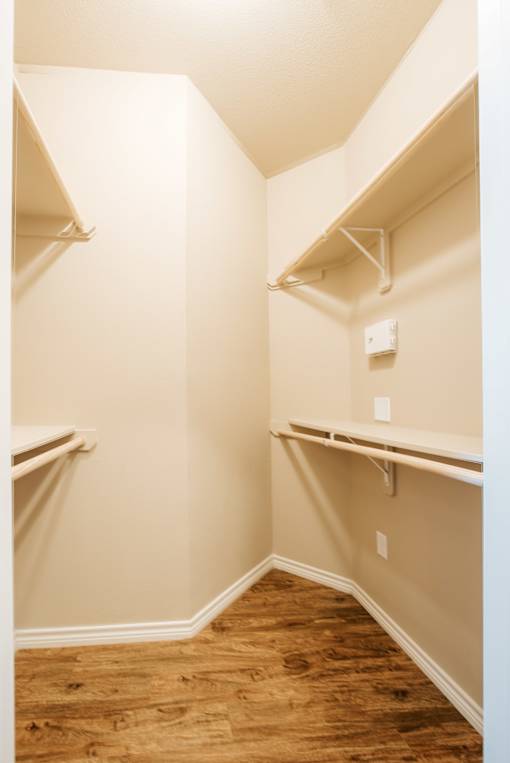 A white wall with a light switch and a white shelf.