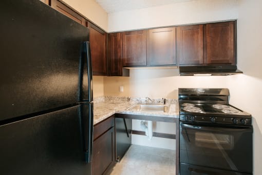 a kitchen with black appliances and brown cabinets