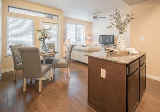 A living room with a brown cabinet and a white vase with greenery on top.