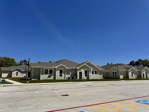 A parking lot with a few houses in the background.