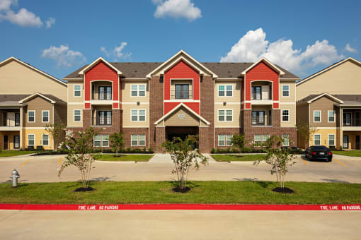 an exterior view of an apartment building with a parking lot