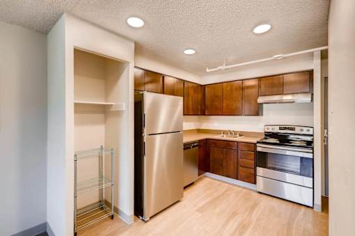 A kitchen with a refrigerator, oven, and stove.