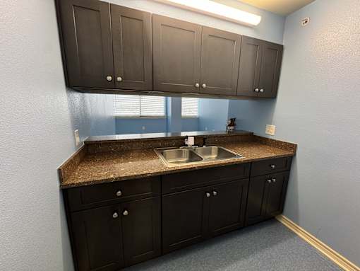 A kitchen with brown cabinets and a granite countertop.