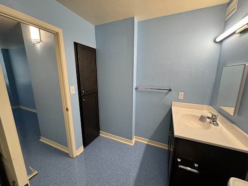 A bathroom with blue walls and a white sink.