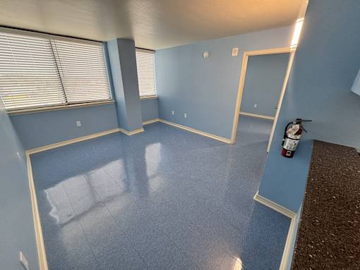 A room with blue walls and a fire extinguisher on the floor.