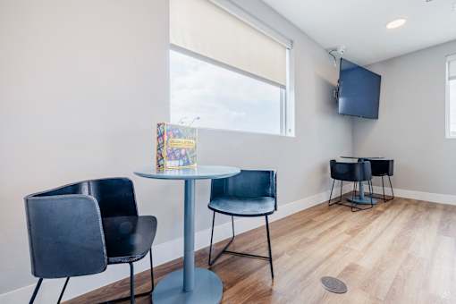 A room with a table, chairs and a television.