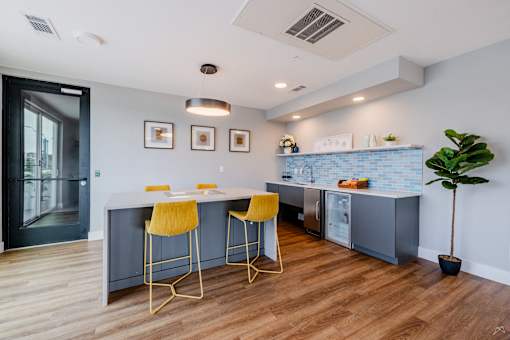 A kitchen with a bar area featuring yellow stools.