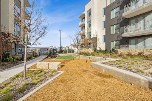 Apartment community exterior with walking path and landscaped grounds