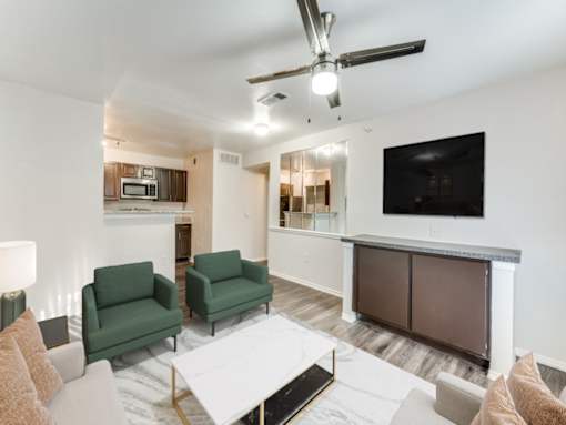 A living room with a white coffee table and green chairs.