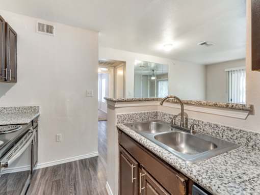 A kitchen with a granite countertop and stainless steel appliances.