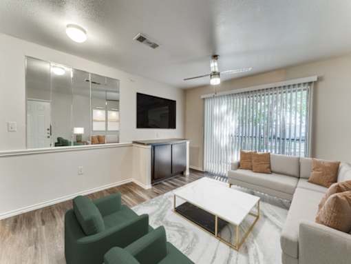A living room with a white couch, green armchair, and a coffee table.
