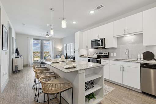 A modern kitchen with white cabinets and a large island