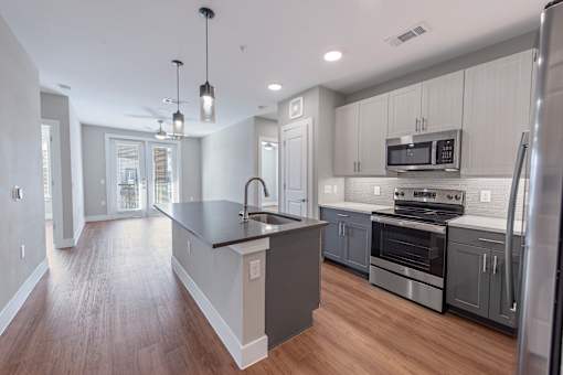 A modern kitchen with a large island and stainless steel appliances.