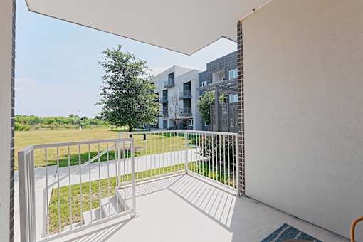 A balcony with a white railing and a white wall.