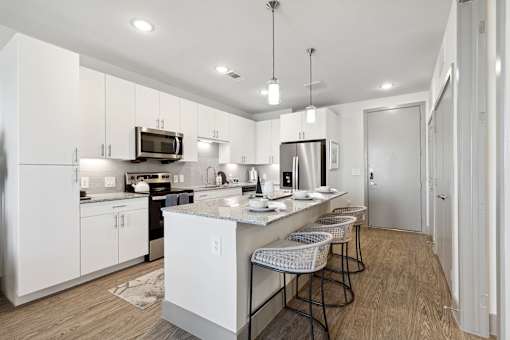 A modern kitchen with white cabinets and a central island.