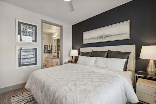 A bedroom with a large bed and two lamps.