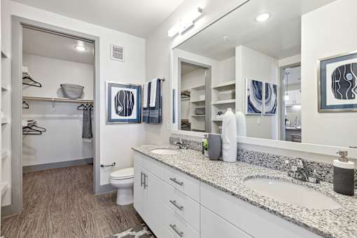 A bathroom with a toilet, sink, and mirror.