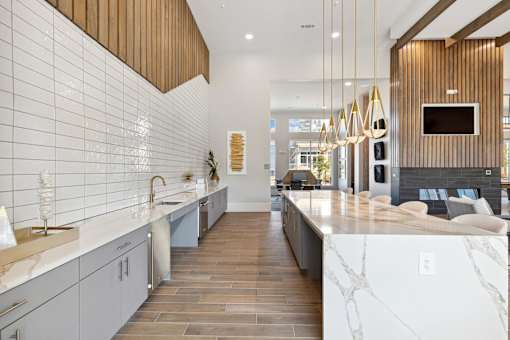 Bright open interior with white shiplap walls, marble countertops and modern pendant lighting