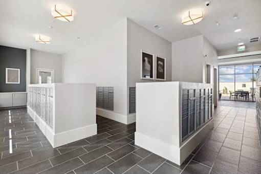 A spacious lobby with a white reception desk and grey tiled flooring