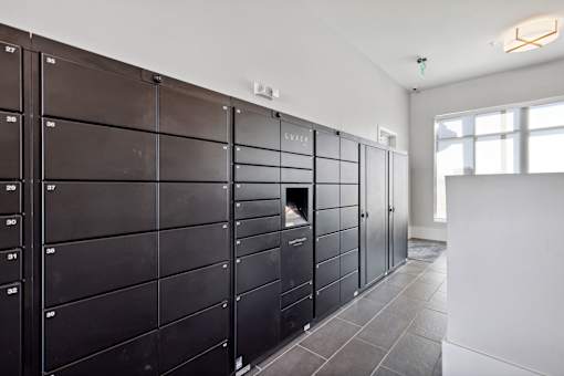 A row of black lockers are lined up in a room.