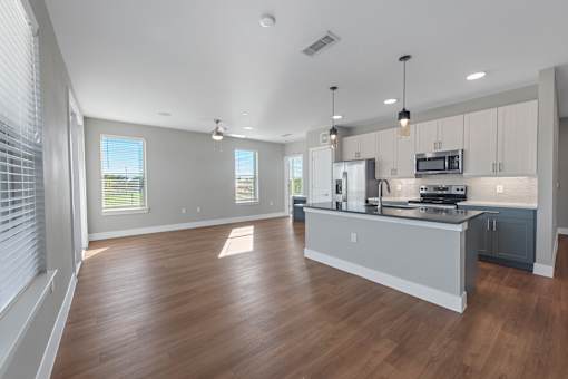A spacious kitchen with wooden floors and modern appliances.