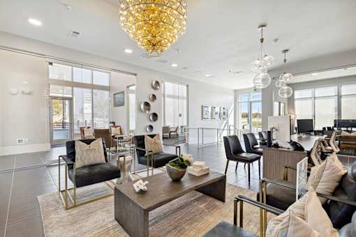 Elegant resident lounge with statement chandelier, dark wood flooring and curated seating