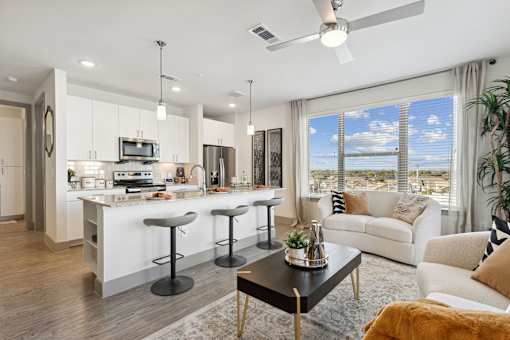 A modern kitchen with white cabinets and a bar area.