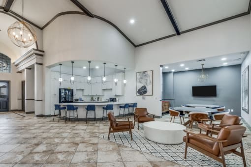 a large lobby with tables and chairs and a tv  at Valor at Harlingen, Harlingen, TX