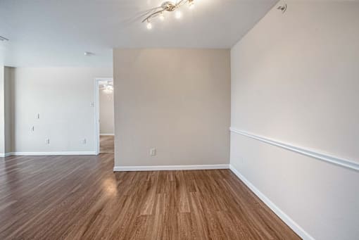 A room with wooden flooring and white walls.