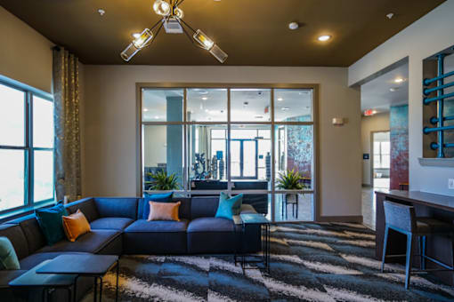 A living room with a blue couch and a black and white rug.