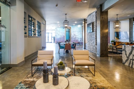 A cozy room with two white chairs and a coffee table in front on them