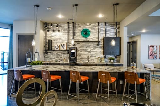A kitchen with a bar area and chairs.