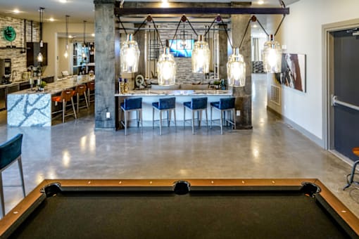 A pool table is in the foreground of this image.