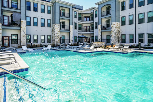 A swimming pool in front of apartment buildings.
