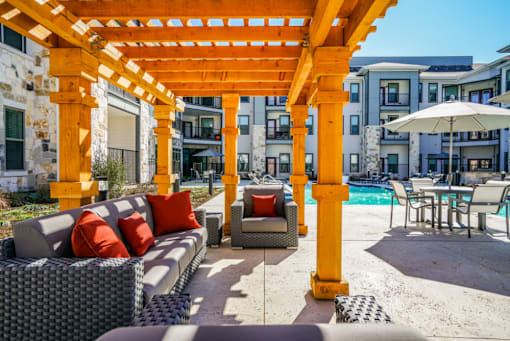 A patio with a yellow pergola and a pool table, Manor, TX