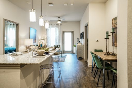 A modern kitchen with a dining area in the background.
