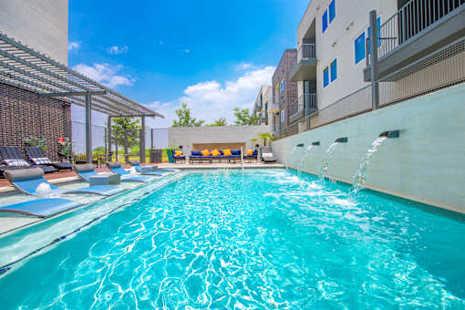 A swimming pool with a waterfall feature in the middle.