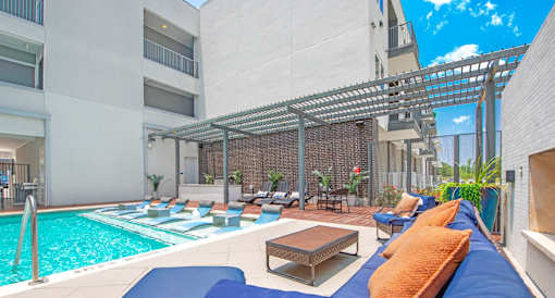A pool area with a blue mat and a wooden table.