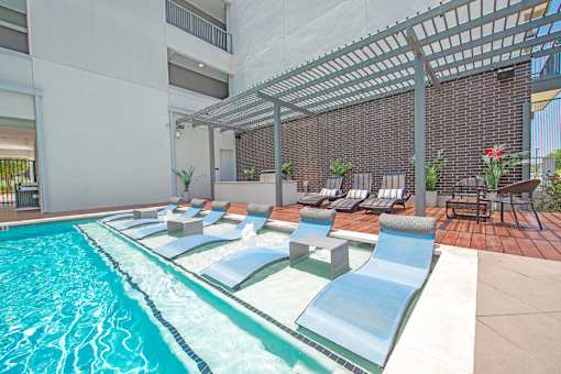 A pool with a slide and sun loungers.