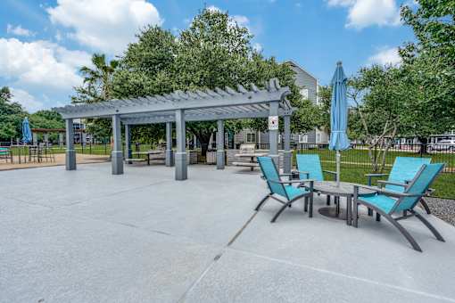 an outdoor patio with chairs and tables and a pavilion at Vibe on Riverside, Austin, TX, 78741