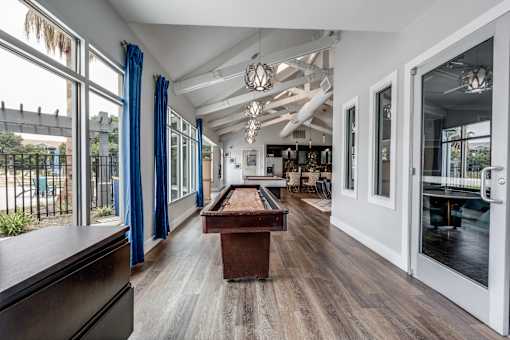 a pool table in the center of a room with glass doors at Vibe on Riverside, Austin, TX