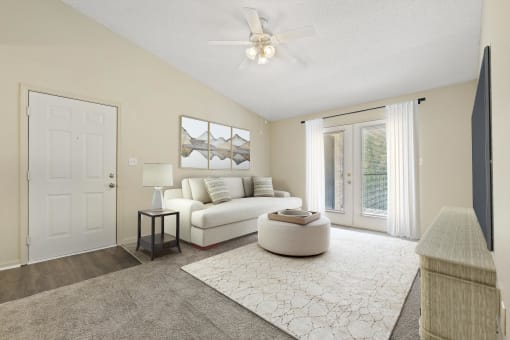 a living room with a white couch and a ceiling fan at Baldwin Farms Apartments, Robertsdale